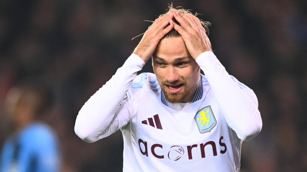 Aston Villa defender Matty Cash places his hands on his head during a game.