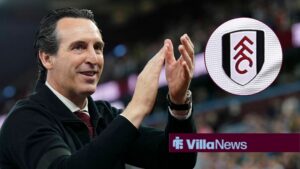 Aston Villa manager claps with the Fulham logo to his right.