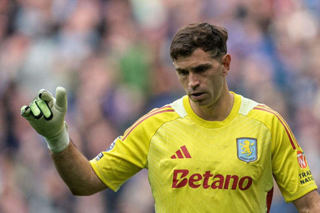 Emi Martinez looking down holding his hand out while playing for Aston Villa