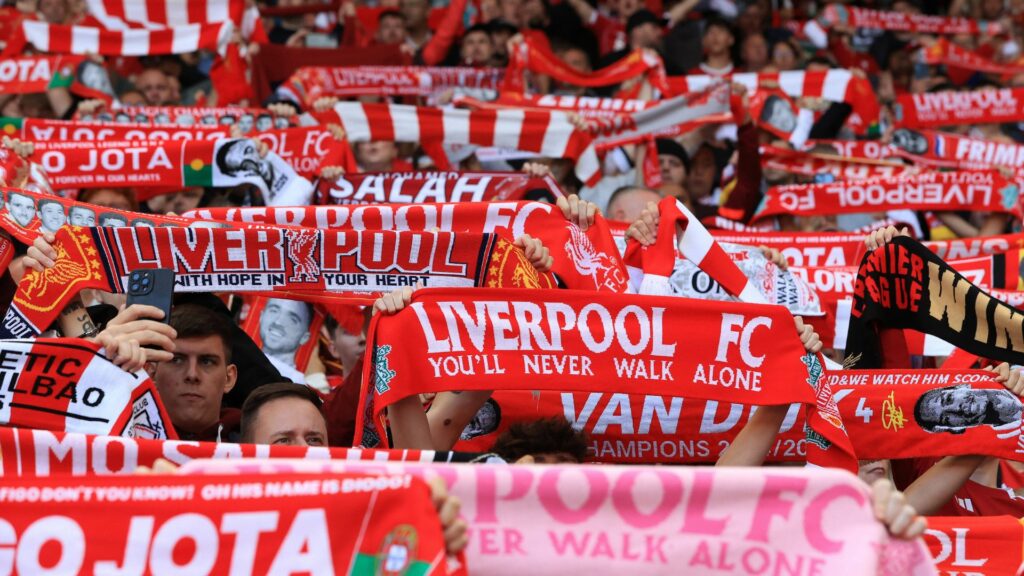 Liverpool fans holding up scarves at Anfield