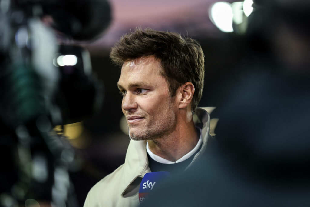 Tom Brady smiling in front of a camera while talking on Sky Sports