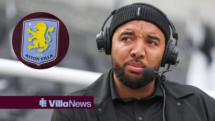 Troy Deeney looking concerned in the direction of an Aston Villa badge.