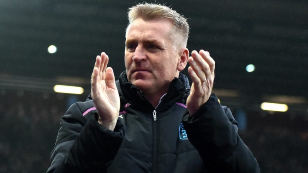 Dean Smith clapping in an Aston Villa coat